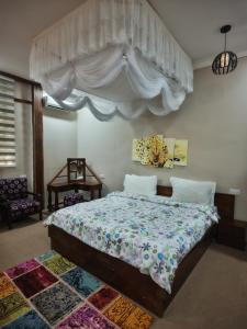 a bedroom with a bed with a canopy at Waghill Presidential Penthouse in Mwanza