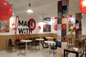 Un restaurante con mesas y sillas y un cartel hecho contigo en Super Townhouse Kachnar House Vikas Nagar, en Lucknow