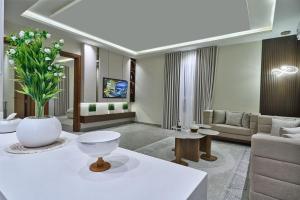 a living room with a couch and a vase of flowers at شقة بثلاث غرف فاخرة وبطراز أنيق in Jeddah