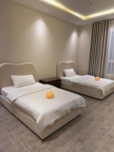 two beds in a hotel room with towels on them at شقة بثلاث غرف فاخرة وبطراز أنيق in Jeddah