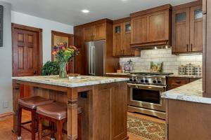 a kitchen with wooden cabinets and a island with a vase of flowers at Luxury Home with Private Hot Tub, Woodburning Fireplace, Pet Friendly in Vail