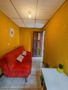 un divano rosso in un soggiorno con pareti gialle di Casa Candelaria, Antigua a Antigua Guatemala