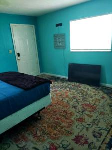 a blue bedroom with a bed and a window at GpL 5544 Cozy Getaway with Bright Colors & Full Kitchen in Fort Myers