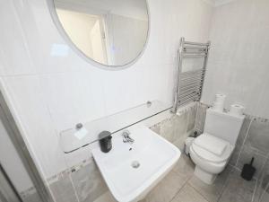 a bathroom with a sink and a toilet and a mirror at Charming 2 bedrooms flat for 6 in King's Cross in London