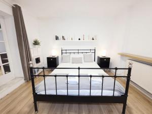 a bedroom with a bed with white walls and wooden floors at Charming 2 bedrooms flat for 6 in King's Cross in London