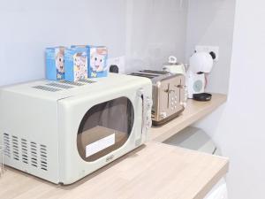 a white microwave sitting on a counter in a kitchen at Charming 2 bedrooms flat for 6 in King's Cross in London