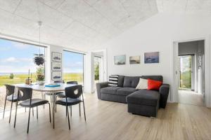 a living room with a couch and a table and chairs at LF18127-Veslos-Livovej-29 in Vesløs +24 photos