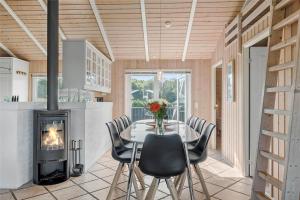 ein Esszimmer mit Tisch und Kamin in der Unterkunft OH118 Storvorde - Kongeørnen 32 in Storvorde