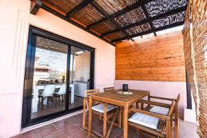 ein Esszimmer mit einem Holztisch und Stühlen in der Unterkunft Book Jet - Bella Vista VIP Villa in Majanicho