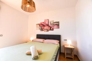 ein Schlafzimmer mit einem Bett und zwei Gemälden an der Wand in der Unterkunft Book Jet - Bella Vista VIP Villa in Majanicho + 24 Fotos