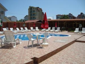 a patio with chairs and a table and a pool at Complex Laguna-Kantardzhiev in Primorsko