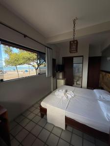 a bedroom with a large bed with a view of a beach at Ingá Praia hotel in Natal