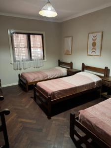 a room with three beds and a window at Casa grande en Miramar con parque, quincho y parrilla in Miramar