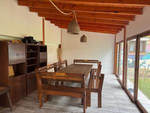 a dining room with a wooden table and chairs at Casa grande en Miramar con parque, quincho y parrilla in Miramar