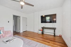 ターポン・スプリングスにあるThe Tarpon Flat Bright 1BR Downtown Retreatのリビングルーム(テーブル、薄型テレビ付)