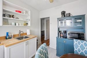 ターポン・スプリングスにあるThe Tarpon Flat Bright 1BR Downtown Retreatのキッチン(青と白のキャビネット、シンク付)