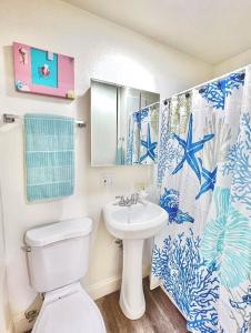 a bathroom with a white toilet and a sink at Beachside retreat in Santa Cruz +10 photos