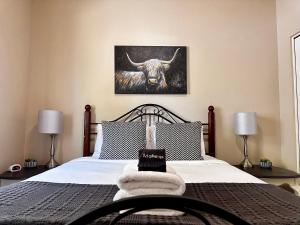 a bedroom with a bed with a bull painting on the wall at Charming 2br Cottage Near Freeway-cul-de-sac in Medford