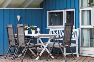 a table and chairs on a porch with a blue wall at FY122-Middelfart-Castorvej-9 in Middelfart +15 photos