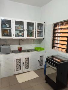 a kitchen with white cabinets and a stove at Two bedroom living room single courtyard villa 