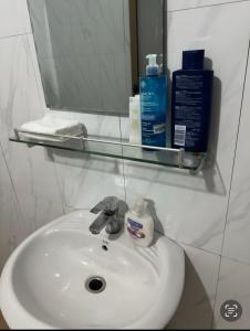 a bathroom sink with a mirror and a bottle of soap at Two bedroom living room single courtyard villa 