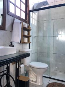 a bathroom with a toilet and a glass shower at Rancho SF Cabana Alabama in Novo Hamburgo