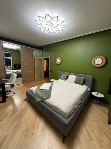 a bedroom with a bed and a green wall at Downtown Kaunas - Maironis 10 in Kaunas