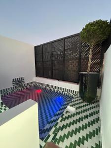 Una piscina con una planta en maceta en el suelo. en Dar Farah Riad luxe privé, 3ch, piscine chauffée, ptit déj, en Marrakech