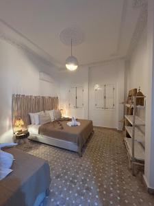 Un dormitorio grande con dos camas y una estantería. en Dar Farah Riad luxe privé, 3ch, piscine chauffée, ptit déj, en Marrakech 56 fotos más