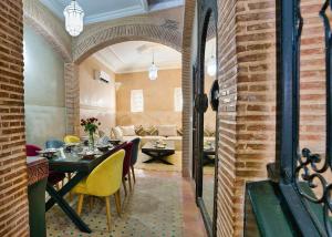 Un comedor con una mesa y sillas amarillas. en Dar Farah Riad luxe privé, 3ch, piscine chauffée, ptit déj, en Marrakech