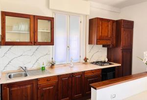 a kitchen with wooden cabinets and a sink and a window at Maison Du Soleil in Somma Lombardo +15 photos