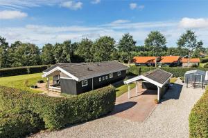 a small black house with a garden and a playground at FY237-Otterup-Vestparken-6 in Otterup