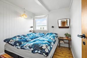 una camera da letto con un letto con un piumone blu e una finestra di FY112-Bogense-Laerkevej-4 a Bogense
