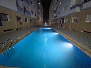 a large swimming pool with blue water in a building at Martil Plage Piscine Fibre & Netflix in Martil