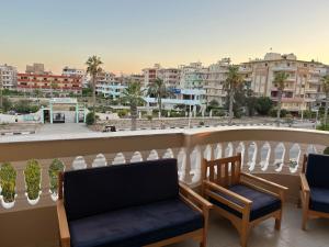 a balcony with two chairs and a view of a city at فندق ألماسه جمصه in Jamaşah