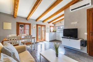 ein Wohnzimmer mit einer Couch, einem Fernseher und einem Tisch in der Unterkunft En el corazon de Palma by Mallorca Infinity in Palma de Mallorca