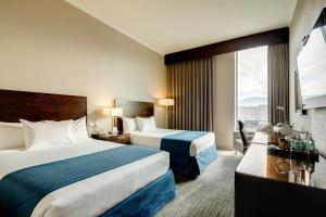 a hotel room with two beds and a window at Wyndham Santiago Aeropuerto in Santiago +89 photos