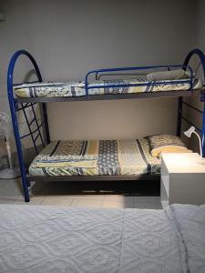 2 Etagenbetten in einem Zimmer mit einem Bett in der Unterkunft Apartamento Familiar 2 con 3 habitaciones 4 camas y litera in San Salvador