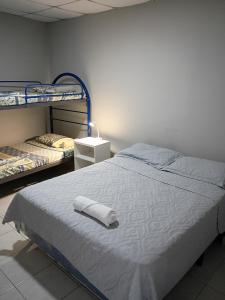 1 Schlafzimmer mit 2 Etagenbetten und einem weißen Bett in der Unterkunft Apartamento Familiar 2 con 3 habitaciones 4 camas y litera in San Salvador