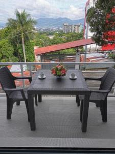 ein Picknicktisch mit zwei Stühlen und einer Blumenschale in der Unterkunft Apartamento Familiar 2 con 3 habitaciones 4 camas y litera in San Salvador