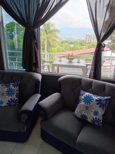 ein Wohnzimmer mit zwei Sofas und einem großen Fenster in der Unterkunft Apartamento Familiar 2 con 3 habitaciones 4 camas y litera in San Salvador + 16 Fotos