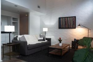 un salon avec un canapé et un mur de briques dans l'établissement 2BR Montrose Aquatic Dream House, Downtown, Medical Center, à Houston