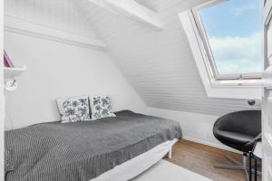 a bedroom with a bed and a window and a chair at FY245-Assens-Ramsherred-25 in Assens