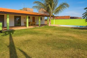 a house with a palm tree and a yard at Chácara com piscina e lazer em Avaré in Avaré