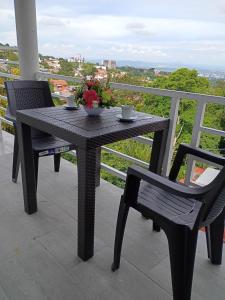 einen Tisch und zwei Stühle mit Blumen auf dem Balkon in der Unterkunft Apartamento Familiar 3 con 3 habitaciones 4 camas más litera in San Salvador