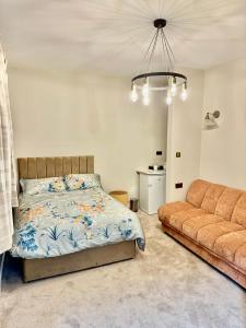 a bedroom with a bed and a couch at Double Deluxe Centre Apartment- Free Parking - Self Check-In - Cctv in Huddersfield