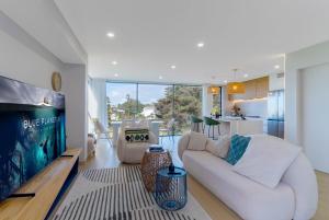 a living room with a white couch and a tv at Great Views in the City in Auckland