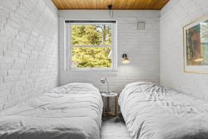 een slaapkamer met een bed en een raam bij LF15143-Hojslev-Mosevej-143 in Højslev