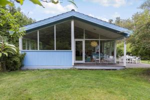 een blauw huis met een veranda met een tafel bij LF15143-Hojslev-Mosevej-143 in Højslev +11 foto's