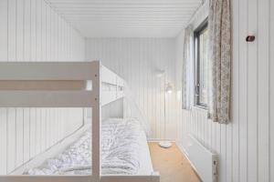 a white bedroom with a bunk bed and a window at FY361-Asperup-Eskelundsvej-18 in Asperup